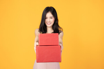 Portrait of happy smiling girl in casual holding gift box and expression face isolated over yellow background