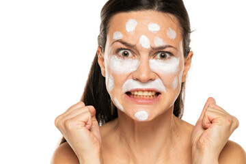 Nervous angry woman posing with face cream