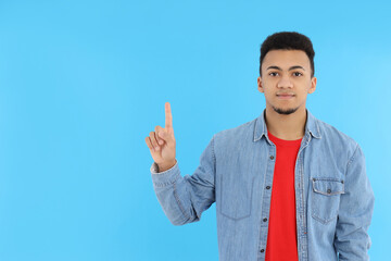 Young man in jeans shirt on blue background