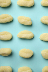 Flat lay with raw potato gnocchi on blue background