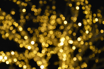 the bokeh lights are yellow. Festive shiny background for celebrating Merry Christmas and Happy New Year. decoration of the city for winter holidays.