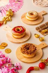 assorted donuts or doughnut plate on wood tray and shoot in cream background and chinese ornament