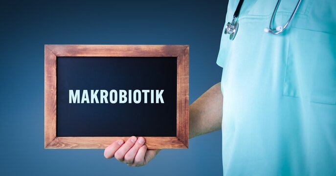 Makrobiotik. Arzt zeigt Schild/Tafel mit Holz Rahmen. Hintergrund blau