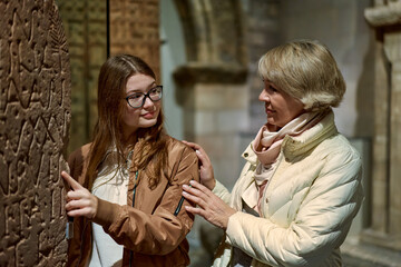 mother and daughter looking at expositions of previous centuries in museum