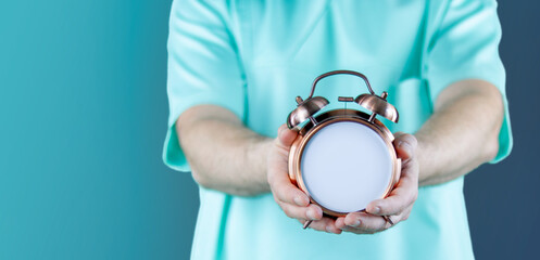 Doktor zeigt Uhr/Wecker mit Text. Hintergrund blau