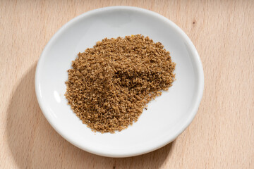 Detailed and large close up shot of powdered coriander on a small plate