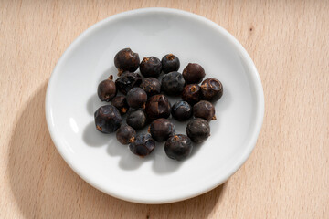 Detailed and large close up shot of juniper berries on a small plate