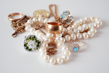 many golden and silver jewelry, pearls on white bakground, pawnshop concept, jewelry shop concept