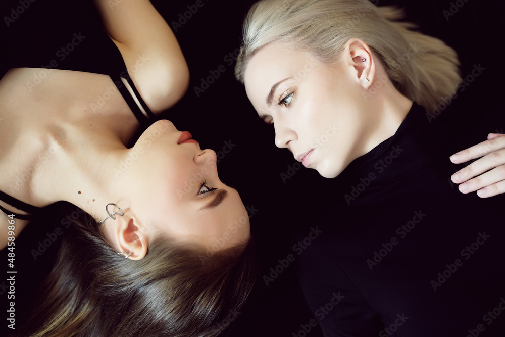 Wall mural top view of two young women on dark background.