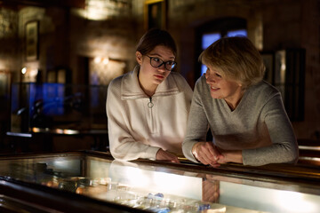 grandmother and granddaughter looking at medieval expositions in museum