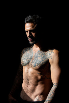 Portrait of handsome man with serious face. Tattooed and elegant hipster. Strong muscular male body, muscles guy. Muscular athletic sexy male, naked torso.