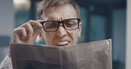 Man having a vision problem while reading a newspaper