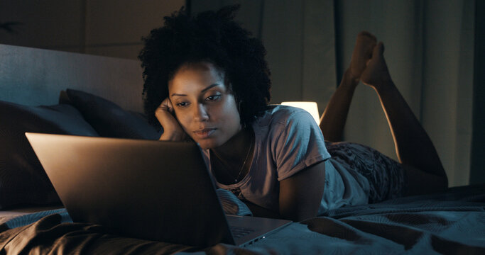 African american woman watching movies at night