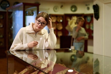 Attentive teenage girl exploring artworks in modern museum