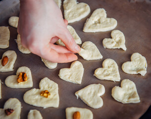 Raw homemade heart-shaped cookies on a baking sheet. Concept of fresh pastry, surprise for Valentine's day