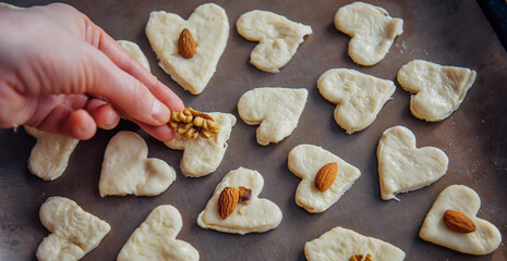 Raw homemade heart-shaped cookies on a baking sheet. Concept of fresh pastry, surprise for Valentine's day