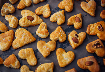 Freshly puff dough heart shaped cookies, top view close up. St Valentine's Day concept. Abstract bakery background with copy space.