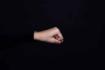 Caucasian person clenched fist isolated on black background. Copy space. Domestic violence. Physical and psychological abuse, relative aggression, gaslighting.
