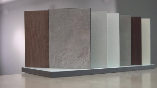 Furniture surface, granite, stone sample tiles for customers. Choosing design for house kitchen interior, countertop table decoration. Marble and wood texture, white, grey ahd brown copies.