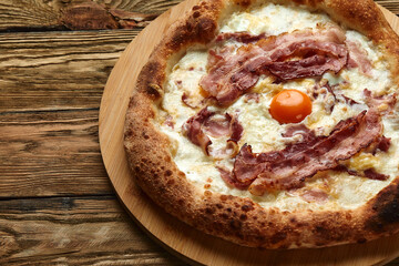 Carbonara pizza with bacon and egg on wooden background