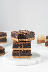 A stack of fudgy brownies, fudgy caramel brownies with a cookie crust, stack of brookies, thick brownie bars