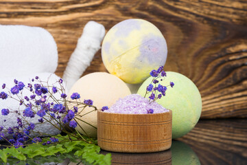 on a wooden background, purple bath salt, for relaxation, in a jar with flowers for fragrance,...