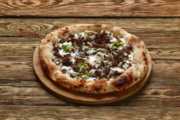 Delicious homemade pizza with mozzarella, mushrooms, beef and chicken. Wooden background, selective focus.