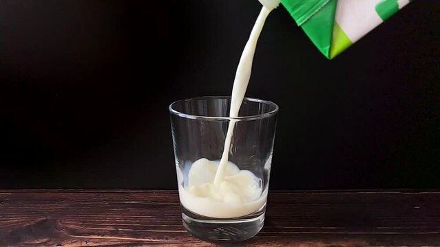 Pouring milk in a glass in slow motion