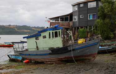 Fototapeta na wymiar Old boat on the shores of Castro Bay, Chile