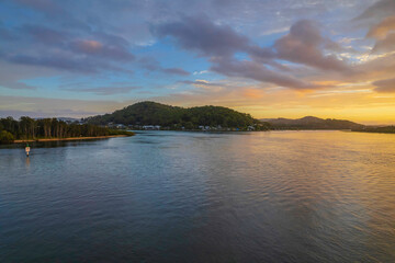 Fototapeta premium Sunrise waterscape with a mix of low, medium and high clouds