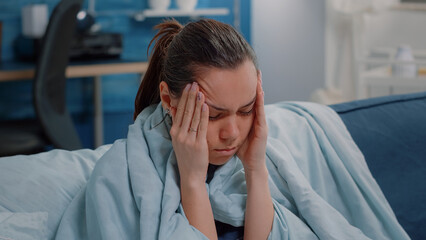 Close up of sick woman with migraine rubbing temples to cure virus disease. Person with headache having seasonal flu symptoms, trying to heal pain and sickness. Adult with coronavirus