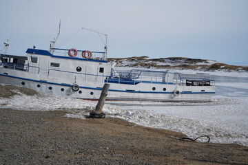 Lake Baikal in winter, snowy winter on the lake, landscape, deep lake in winter, Russia in winter, boat on the shore in winter