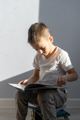 boy sitting on a chair with a book