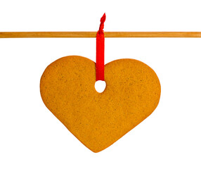Gingerbread heart on a red rope isolated on white background