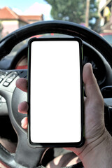 A man using a smartphone while driving a car, point of view. White screen template