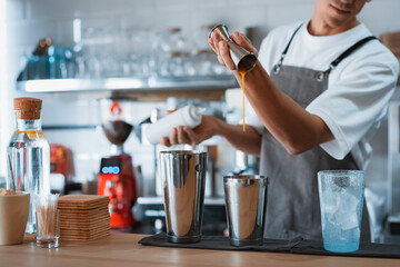professional male barista making caramel iced frappe while working in local coffee shop