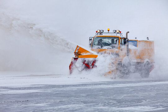 Snow plow on the runway in a snowstorm