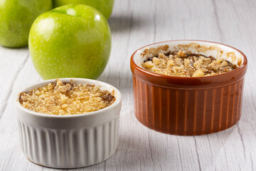 Apple crumble in ramekin on the table.