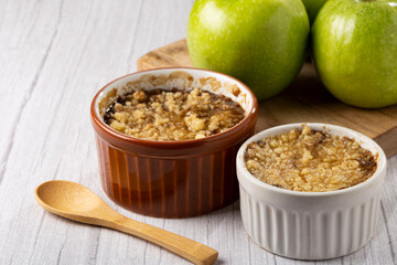 Apple crumble in ramekin on the table.