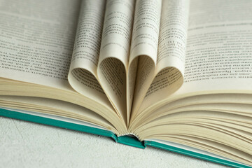 an open book with folded pages in the shape of a heart 
