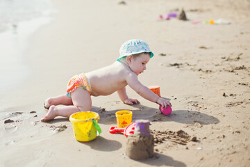 Baby boy plays on beach sea