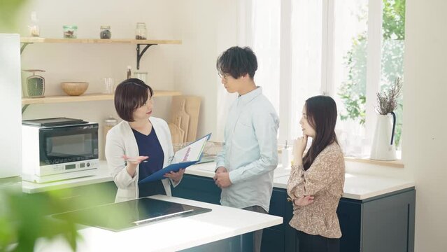 カップルに部屋を案内する女性担当者　モデルハウス　ハウスメーカー　部屋探し