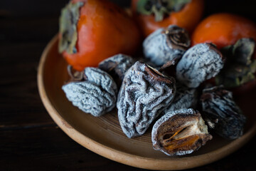 Dried persimmon and fresh persimmon on a wooden background. Healthy diet. Healthy diet