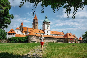 Girl walking to Bouzov Castle,Czech Republic.Romantic fairytale chateau with eight-storey watchtower built in 14th century.National cultural monument,popular tourist place.Picturesque location