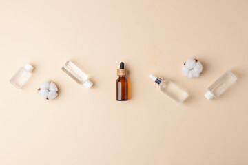 Naklejka premium Cosmetic skin care products with flowers on pastel beige background. Flat lay, copy space