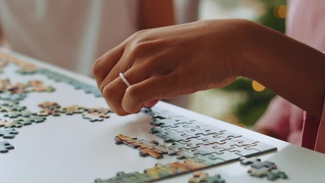 Female hands do jigsaw puzzles at home