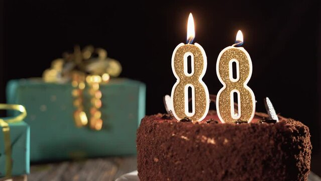 Number eighty eight birthday candle on sweet cake on the table, 88th birthday. Fire from the lighter, blow out the holiday candle.