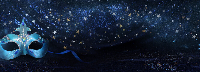 Photo of elegant and delicate Venetian mask over blue dark stars background © tomertu