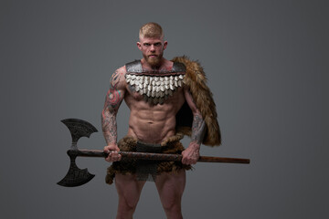 Strong viking fighter with fur holding two handed axe
