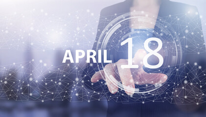 April 18th. Day 18 of month, Calendar date. Hand click luminous hologram calendar date on light blue town background. Spring month, day of the year concept.